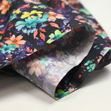 Coton imprimé fleuri graphique orange et violet fond noir