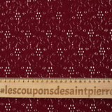 Maille polyester ajourée fleurs fond bordeaux