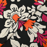 Fine viscose satin printed with fuchsia, orange and ecru royal flowers on a black background