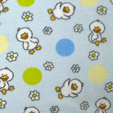 Fleet comforter printed with flowers and ducklings on a sky blue background