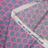 Popeline enduite imprimée végétal turquoise fond rose