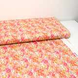 Mandarina y algodón con estampado de flores de mandarín rosa por metro