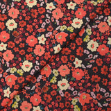 Crêpe polyester imprimé fleurs corail fond marron
