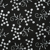 Twill de polyester brodé marguerite fond noir