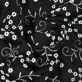Twill de polyester brodé marguerite fond noir
