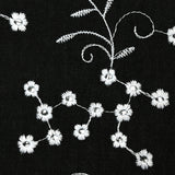 Twill de polyester brodé marguerite fond noir