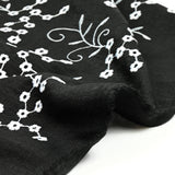 Twill de polyester brodé marguerite fond noir