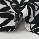 Viscosa estampada con hojas de bambú negras sobre fondo blanco