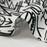 Viscosa estampada con graffitis negros sobre fondo blanco