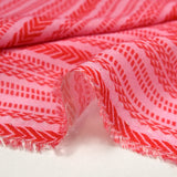 Voile de viscose et laine imprimé aztèque rouge fond rose