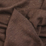 Maille de laine fine irisée dorée fond marron