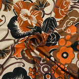 Viscose jersey printed field of orange and brown flowers on beige background