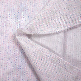 Fina encuadernación de algodón con lentejuelas de manos rosas y azules sobre fondo blanco.