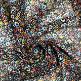 Mousseline crinkle imprimée irisée miette de fleur fond noir