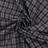 Tejido de polialgodón teñido con cuadros azul marino y burdeos oscuro sobre un fondo gris moteado.