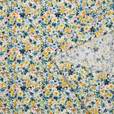 Digital printed cotton voile with small yellow and blue watercolor flowers on a white background