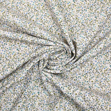 Voile de coton imprimé digital fleurettes bleues et feuillage vert sur fond écru