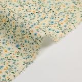 Voile de coton imprimé digital fleurettes jaunes et feuillage vert sur fond crème