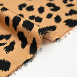 Crêpe satiné de polyester sauvage noire fond mordoré