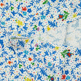 Jersey de viscose satiné imprimé fleurs bleues fond confetti multicolore