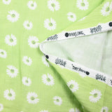 Double gauze printed with daisy smiley face, apple green background