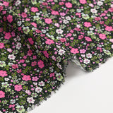 Digital printed cotton voile meadow of small fuchsia and apple green flowers on a black background
