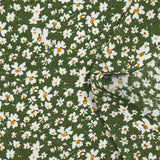 Viscosa estampada con flores blancas y amarillas, fondo caqui.