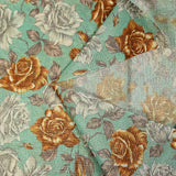 Ramo de rosas amarillas y grises en malla de poliéster lamé sobre fondo verde agua