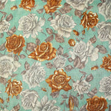 Ramo de rosas amarillas y grises en malla de poliéster lamé sobre fondo verde agua