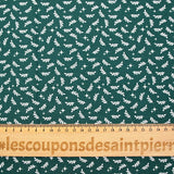 Cotton poplin printed with white twigs and stars on a green background