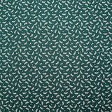 Cotton poplin printed with white twigs and stars on a green background