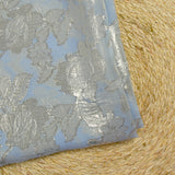 Mousseline de soie jacquard lancé découpé fleurs fond bleu clair
