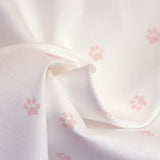 Tissus Piqué de coton imprimé pattes de chien roses sur fond blanc