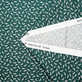 Cotton poplin printed with white twigs and stars on a green background