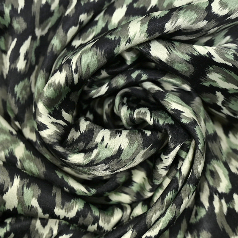 Satin polyester imprimé Urus vert pâle fond noir