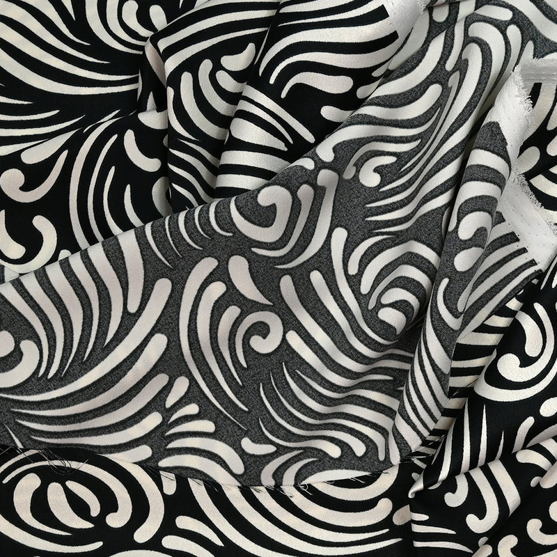 Crêpe satin polyester imprimé l'enfant des dunes blanc cassé fond noir