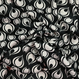 Polyester satin crepe printed tears of the ecru peacock black background