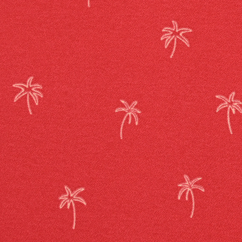 Crêpe de polyester palmiers fond rouge corail