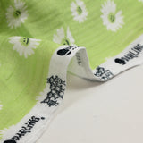 Double gauze printed with daisy smiley face, apple green background