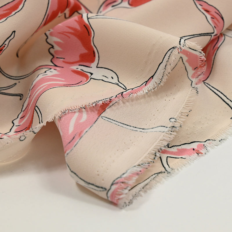 Crêpe de polyester imprimé vol du flamant fond rose chair