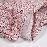 Coton imprimé ouragan floral rose fond blanc