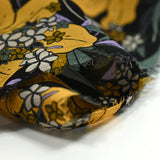 Mousseline de polyester imprimée fleurs jaune et vert fond noir