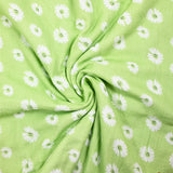 Double gauze printed with daisy smiley face, apple green background