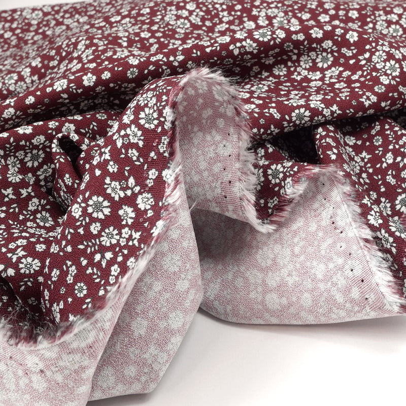 Crêpe viscose imprimé petites fleurs blanches fond bordeaux foncé