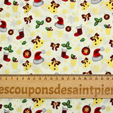 Popeline de coton imprimée bonnets du Père Noël, chaussettes et houx fond écru