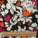 Fino raso de viscosa estampado con flores reales fucsia, naranja y crudo sobre fondo negro