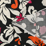 Fino raso de viscosa estampado con flores reales fucsia, naranja y crudo sobre fondo negro