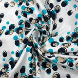 Satin de coton élasthanne dans les bulles turquoise fond blanc