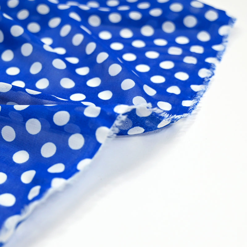 Mousseline de polyester imprimée pois blanc fond bleu