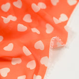 Mousseline de polyester imprimée coeur fond orange